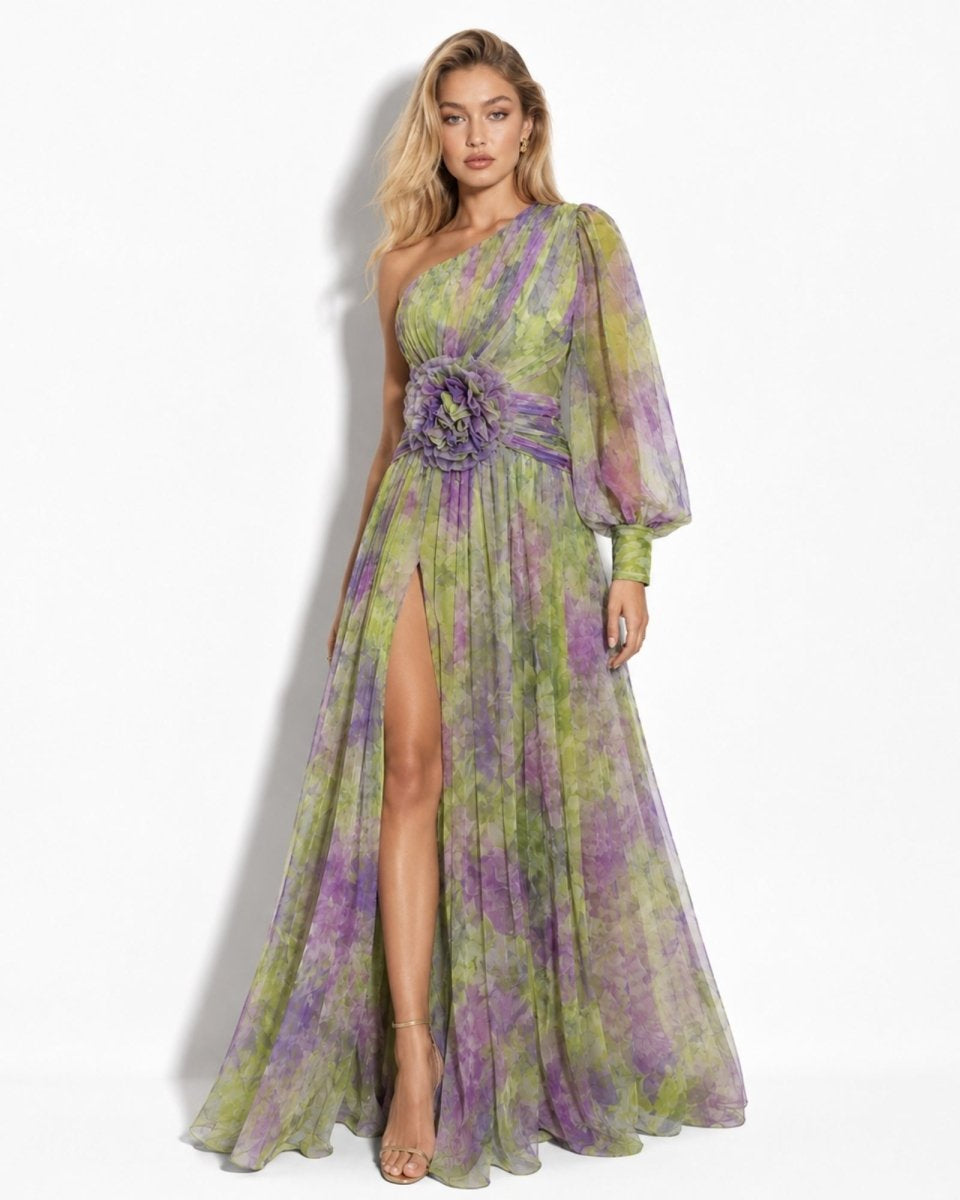 Woman wearing a green and purple floral dress with a slit on a white background