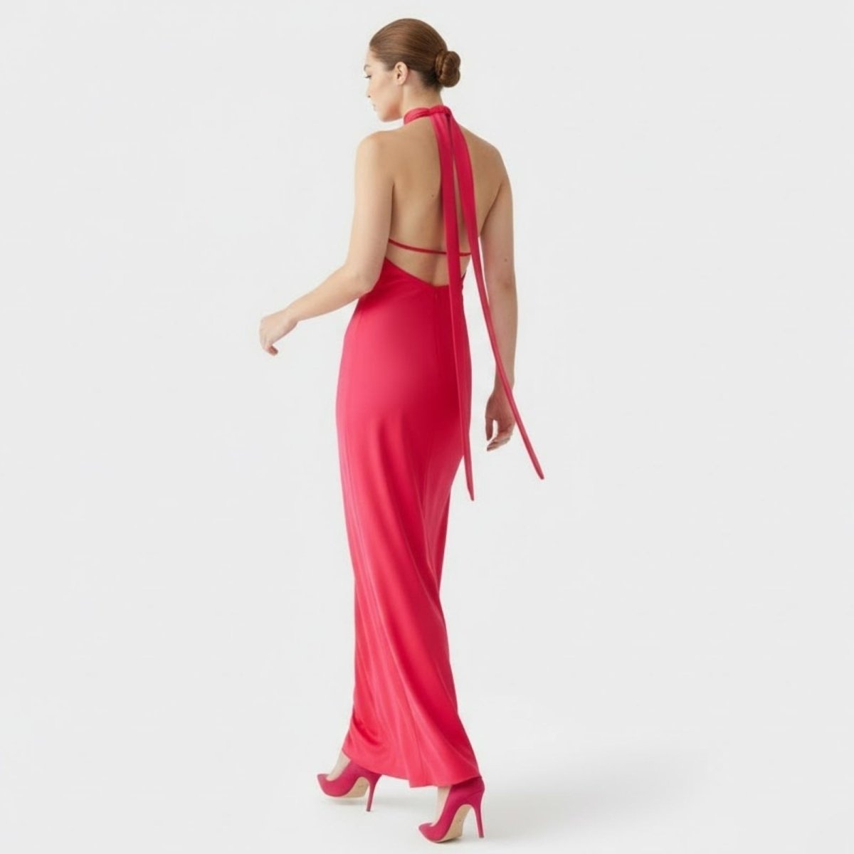 Back view of the Kouvr Sharon maxi dress in fuchsia red , highlighting the open back design with long, flowing sash ties.