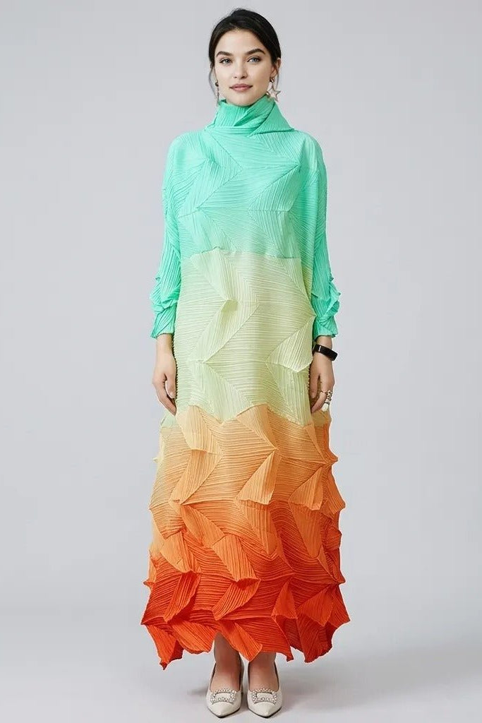Woman wearing Fenlo Form architectural gradient pleated maxi dress in mint green fading to bright orange, front view.