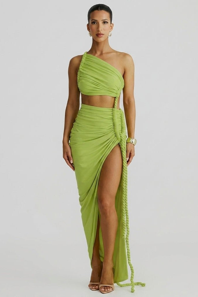 Woman wearing Fenlo Form green one shoulder cutout ruched maxi dress with high thigh slit facing forward