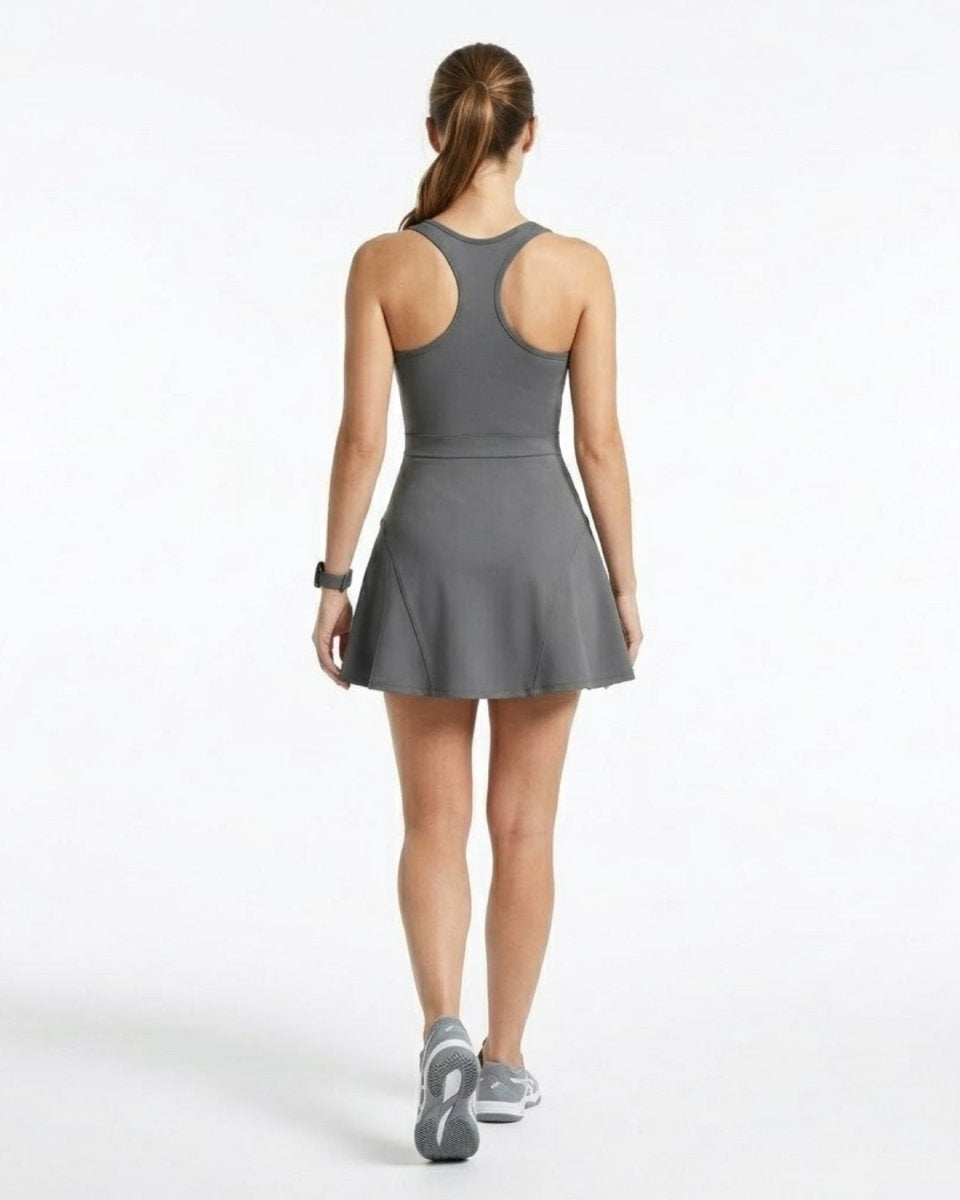 Back view of a grey racerback sports dress showing contoured structural seams and flared skater skirt