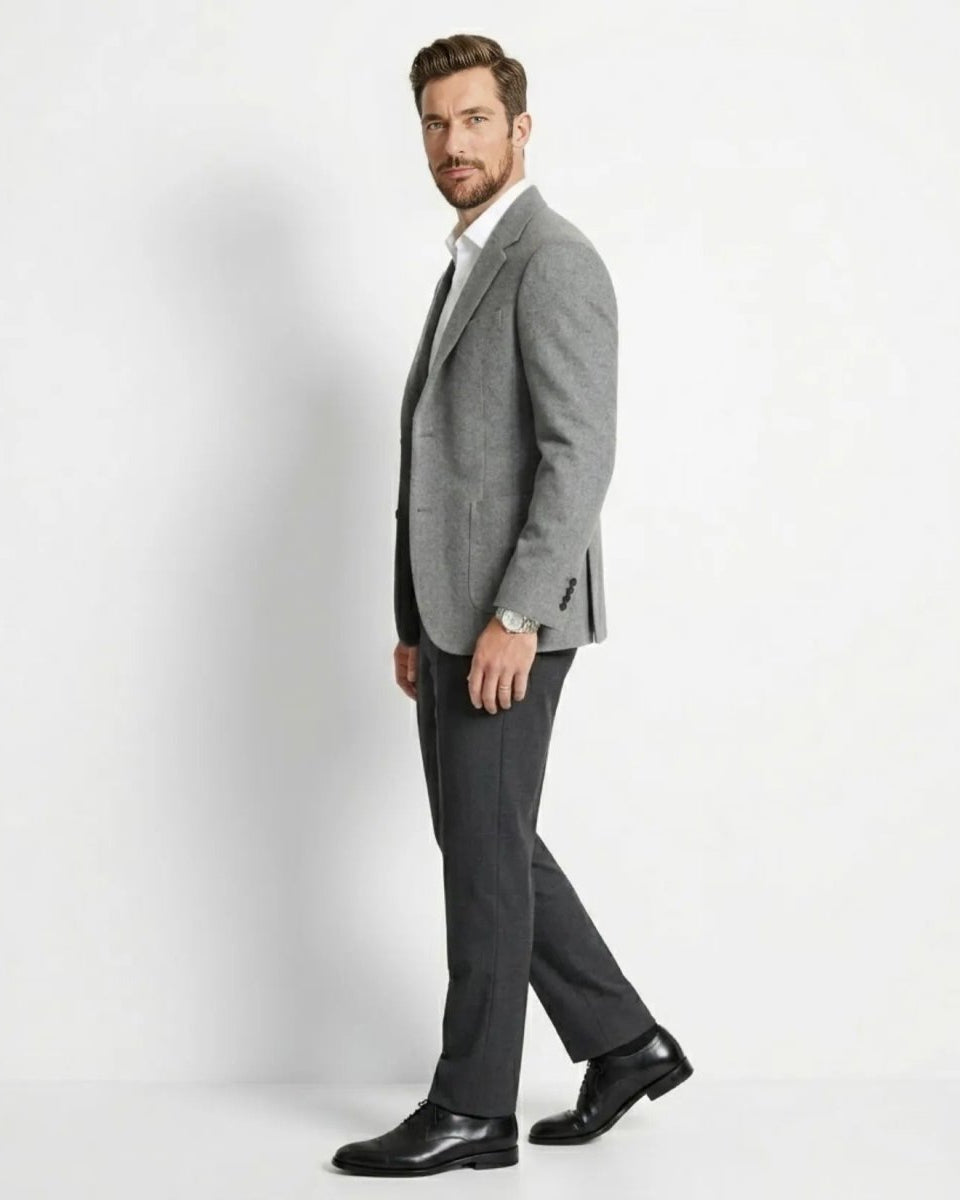 Man wearing a gray suit with a white shirt on a light gray background