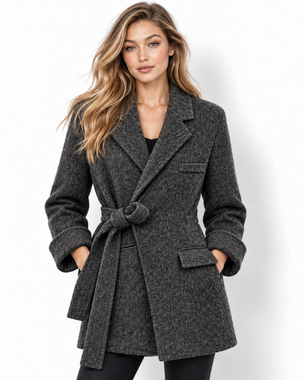 A woman modeling a dark gray textured belted coat against a plain white background.