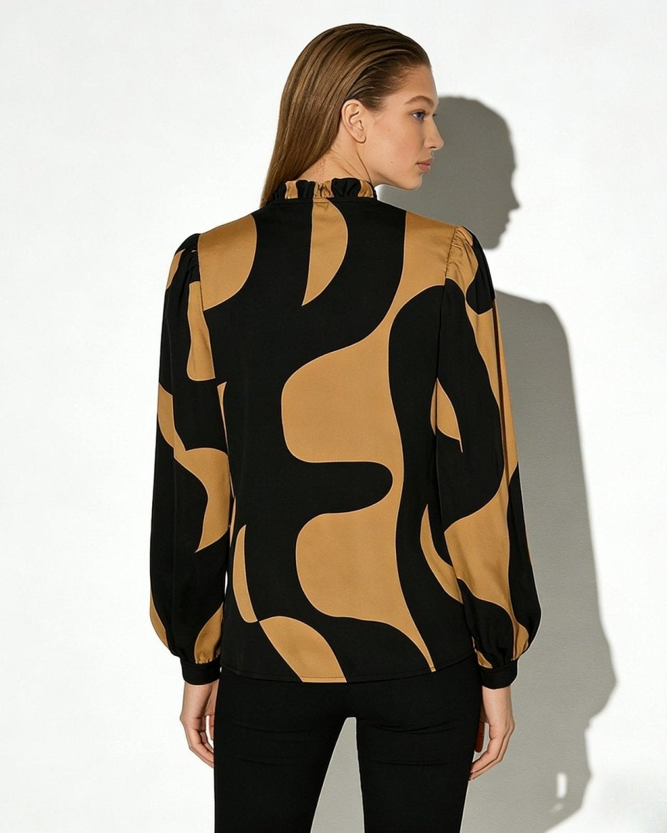 Back view of the Judith blouse showing the high ruffled mock neck and the continuation of the bold black and tan pattern.