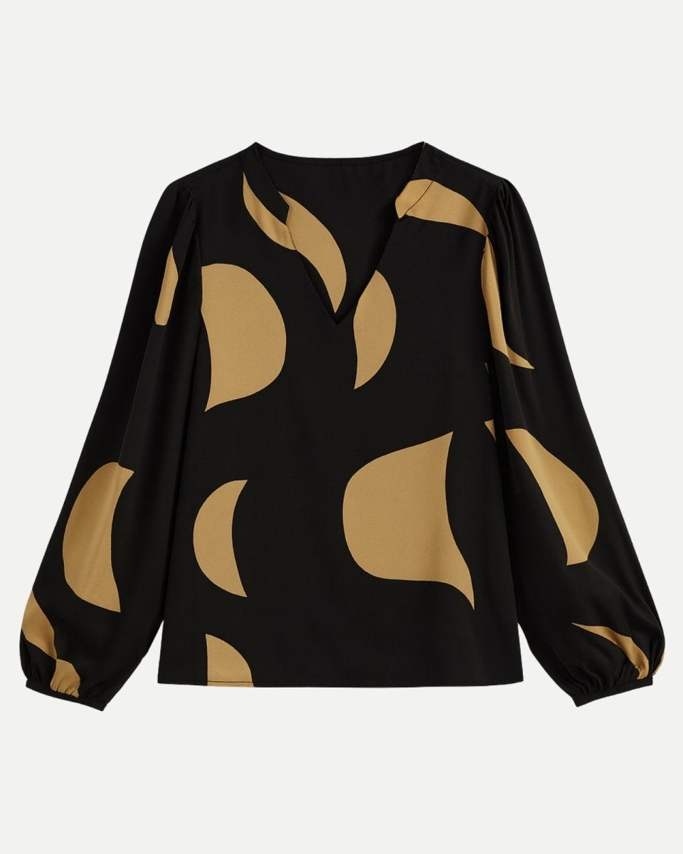 Flat lay of the Judith V-neck blouse, clearly displaying the abstract tan pattern on the black fabric and the shape of the bishop sleeves.