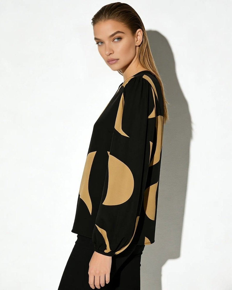 Side view of a model in the Judith abstract print blouse showcasing the voluminous bishop sleeve and fluid drape of the fabric.