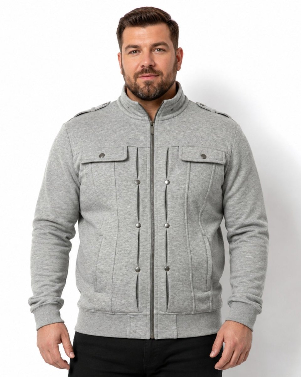 A man wearing a light gray heather zip-up jacket with a stand collar, buttoned chest pockets, and shoulder epaulets, paired with black pants, against a plain white background.