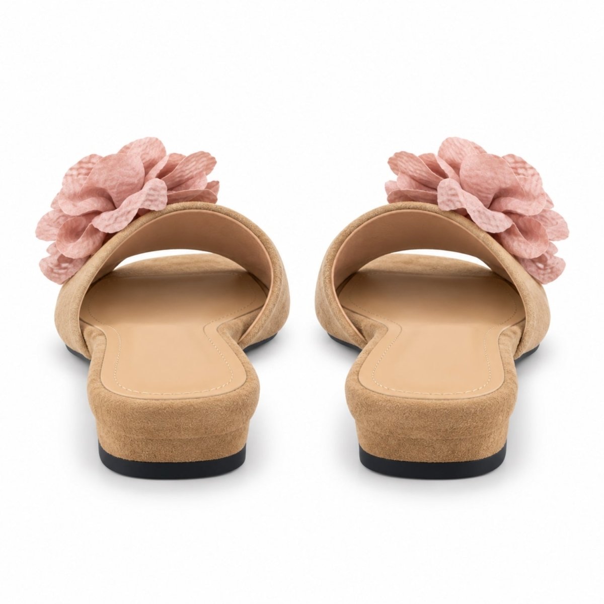 A pair of women's slide sandals shown from the back, featuring a tan suede-like upper with a large textured pink fabric flower on each strap, set against a plain white background.