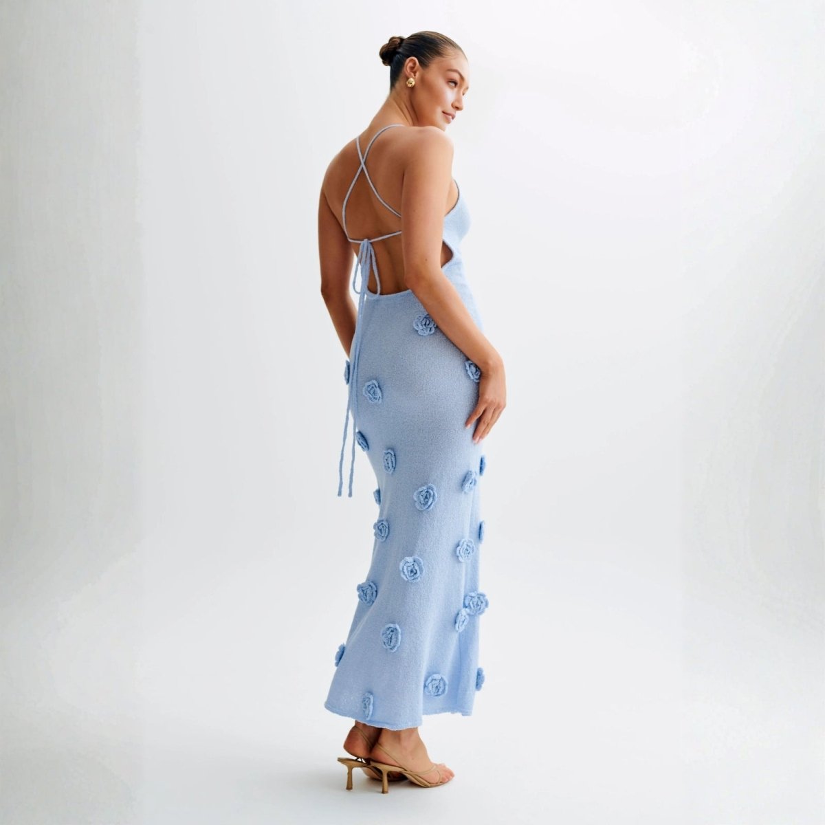 Model wearing the alexie light blue kouvr knit maxi dress with 3D rosettes by Kouvr Fashion, front view.
