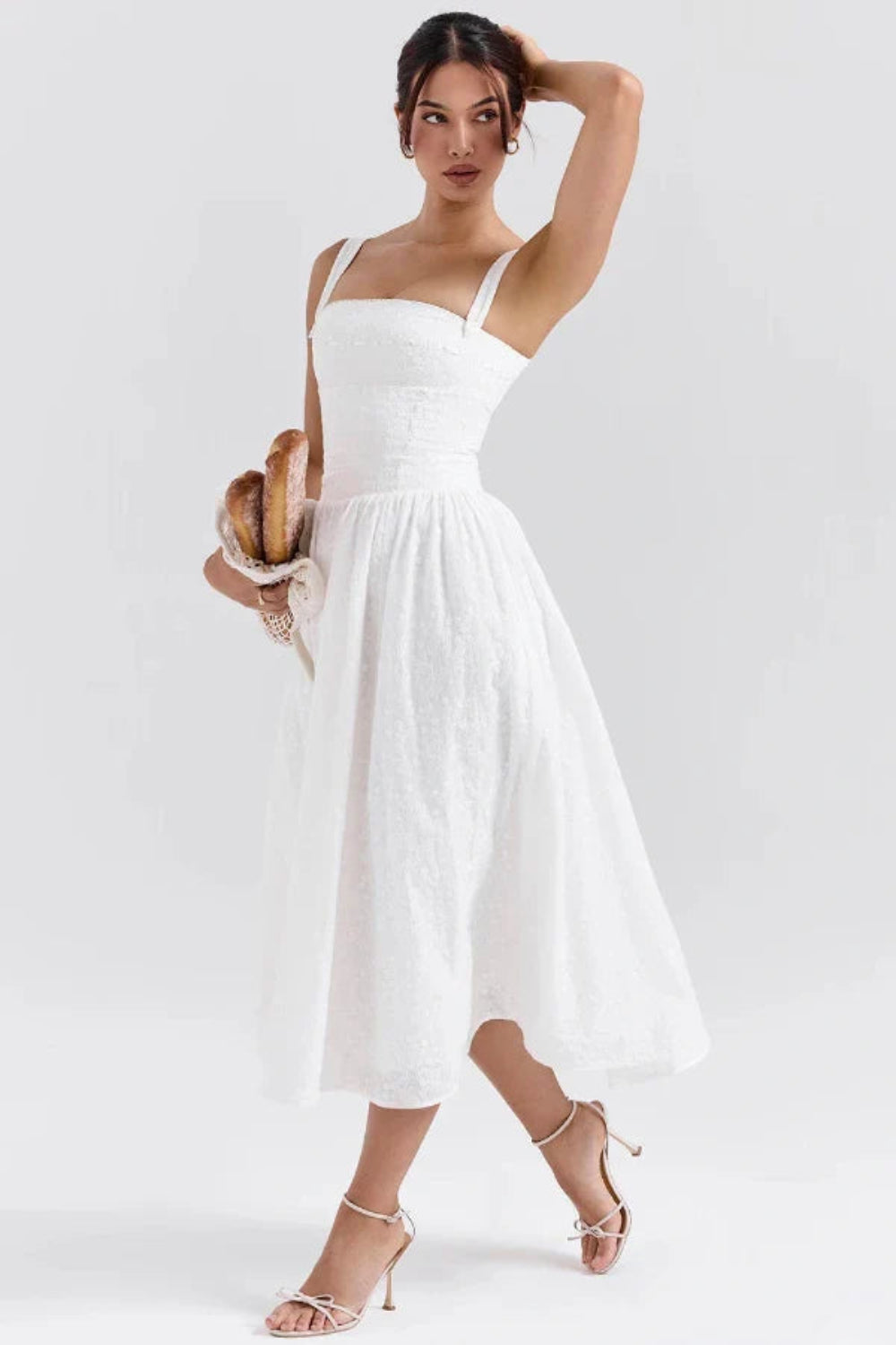 Model wearing Kouvr Apolline white corset midi dress with a square neckline and full A-line skirt
