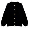 Flatlay product shot of the Kouvr black oversized cardigan showing all six gold buttons and chunky knit detail.