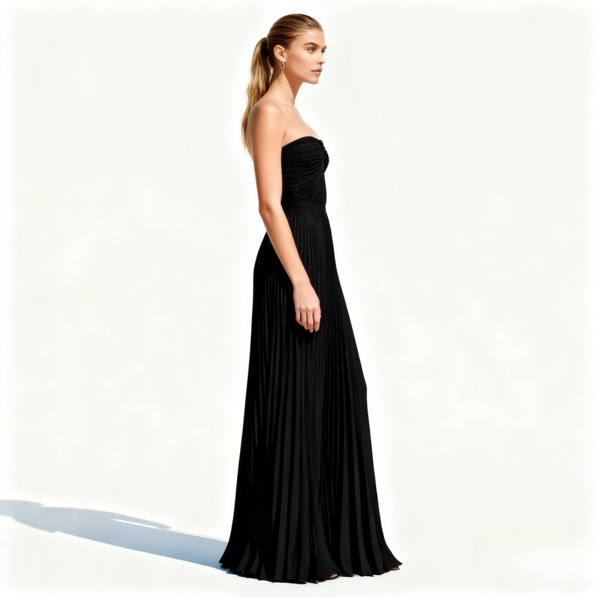 Woman wearing a black kouvr strapless gown on a white background
