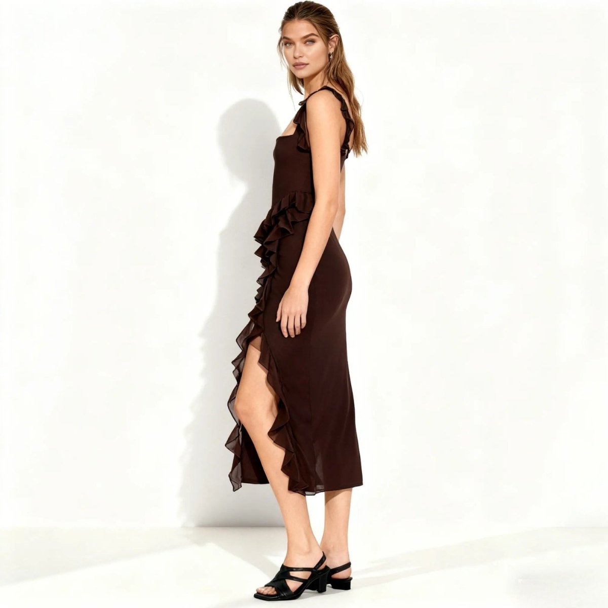 Woman wearing a brown Kouvr dress with ruffles on a white background
