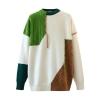 Product shot of the Kouvr patchwork sweater showing the front. Detailed view of the cable knit green panel, diamond knit brown panel, and contrast stitching.