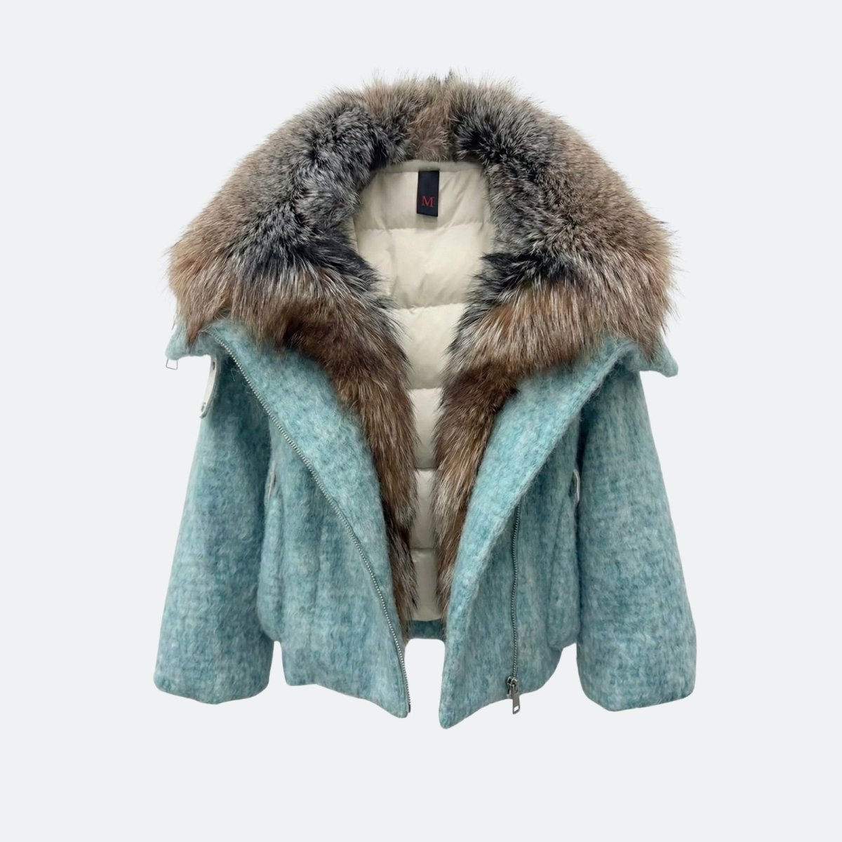 Product shot of the unzipped Kouvr Dorothy light blue wool jacket showing the plush fox fur collar and the white quilted puffer lining.