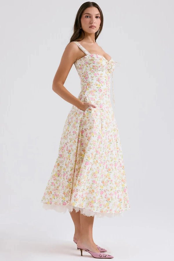 Model wearing Kouvr Fashion Aviva floral corset midi dress in white with pink and yellow flowers, showing the lace-up bustier and A-line skirt
