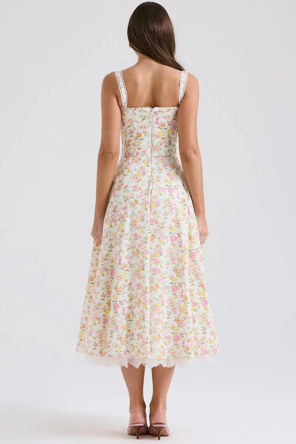 Model wearing Kouvr Fashion Aviva floral corset midi dress in white with pink and yellow flowers, showing the lace-up bustier and A-line skirt