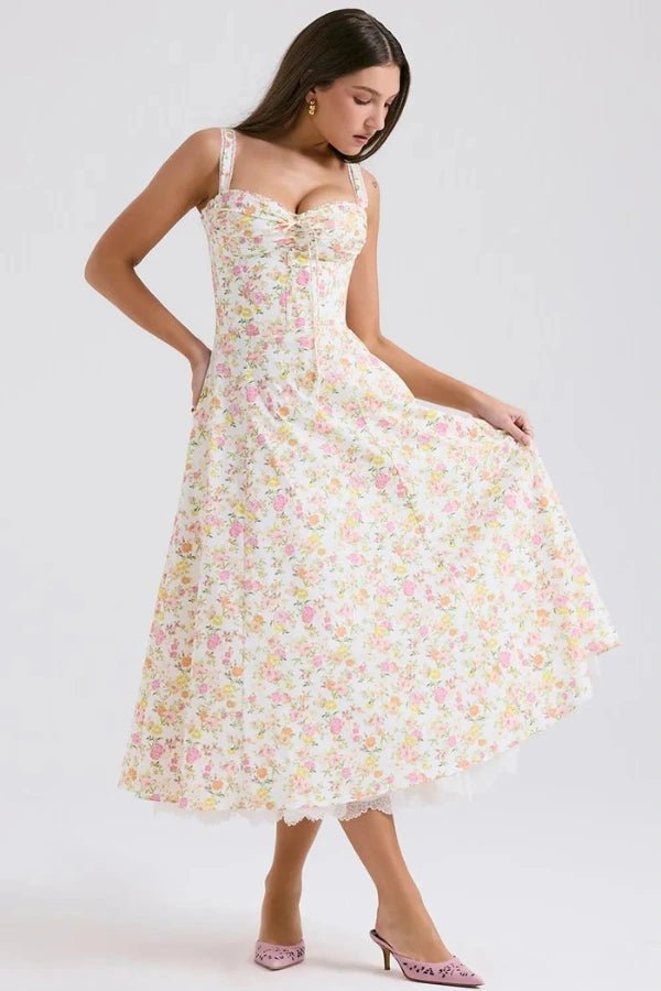 Model wearing Kouvr Fashion Aviva floral corset midi dress in white with pink and yellow flowers, showing the lace-up bustier and A-line skirt