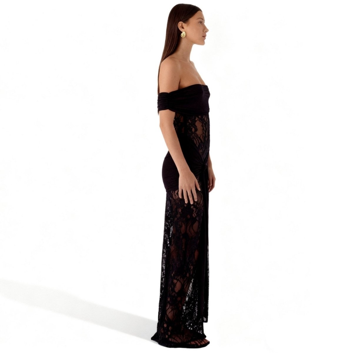 Woman wearing a black Kouvr off-shoulder lace dress on a white background