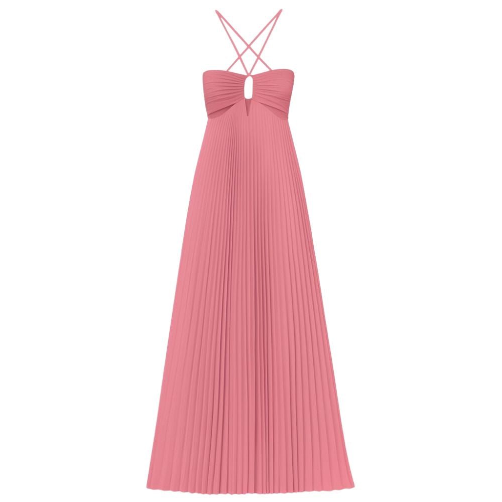 Model wearing the Kouvr Daphne Gown, a pink pleated halter maxi dress with waist cutouts, in a stone courtyard