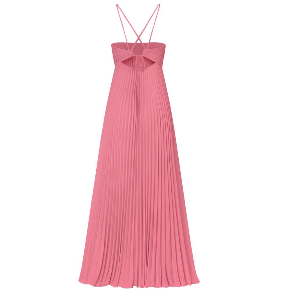 Model wearing the Kouvr Daphne Gown, a pink pleated halter maxi dress with waist cutouts, in a stone courtyard