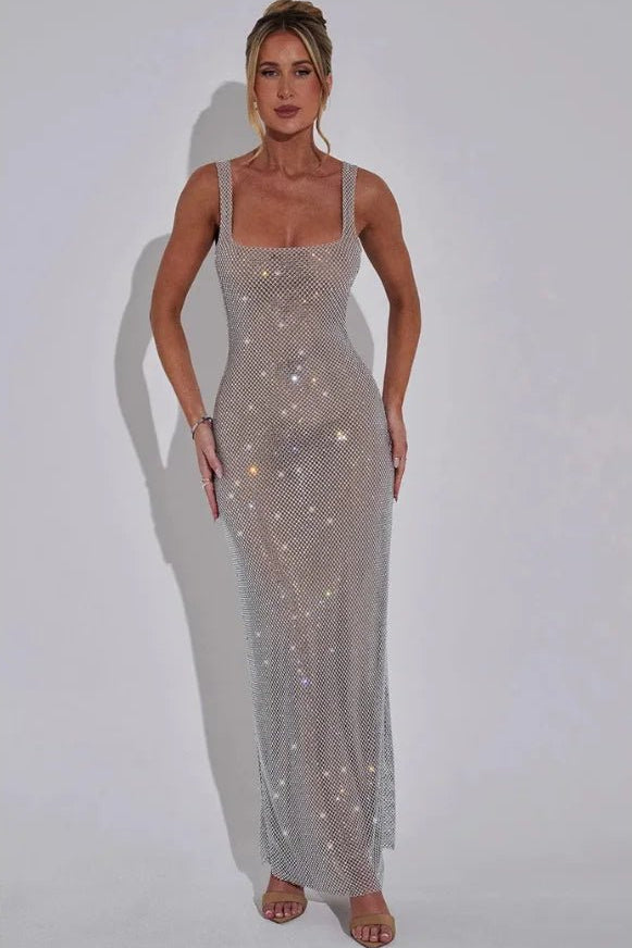Model wearing the Kouvr Fashion Isabeu Gown, a silver floor-length rhinestone crystal mesh dress with a square neckline