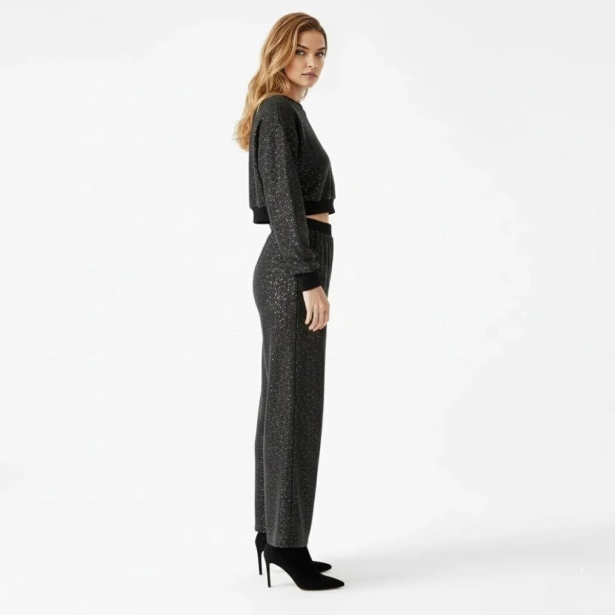 Side profile of a model wearing the black glitter two-piece outfit by Kouvr Fashion, showcasing the silhouette and fit.