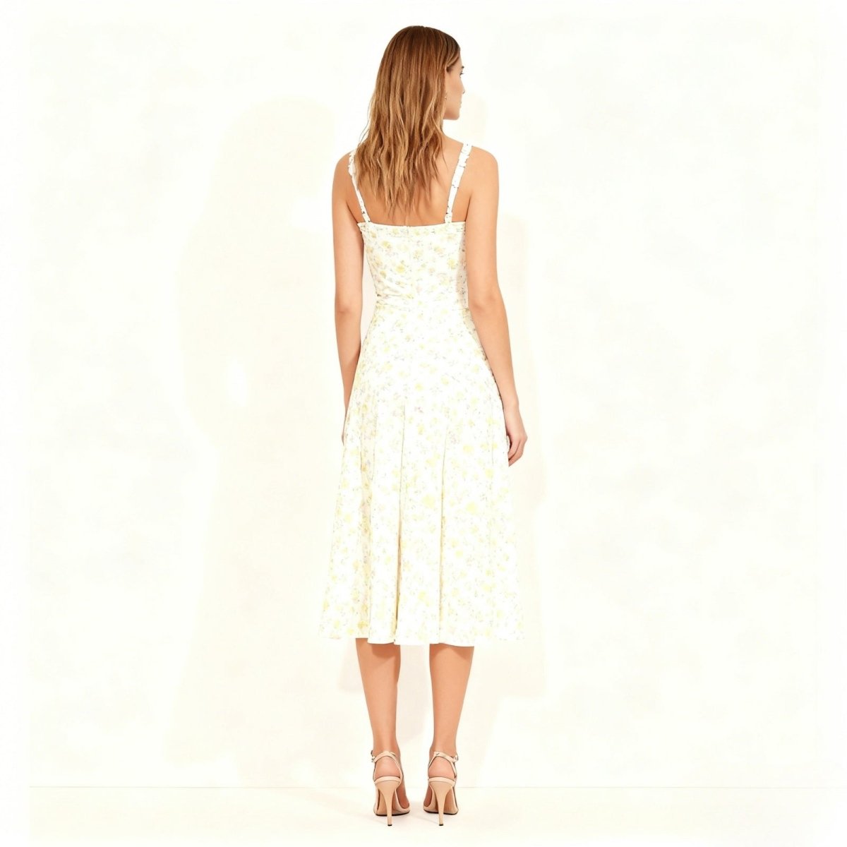Woman wearing a ivory kouvr dress with floral patterns on a white background