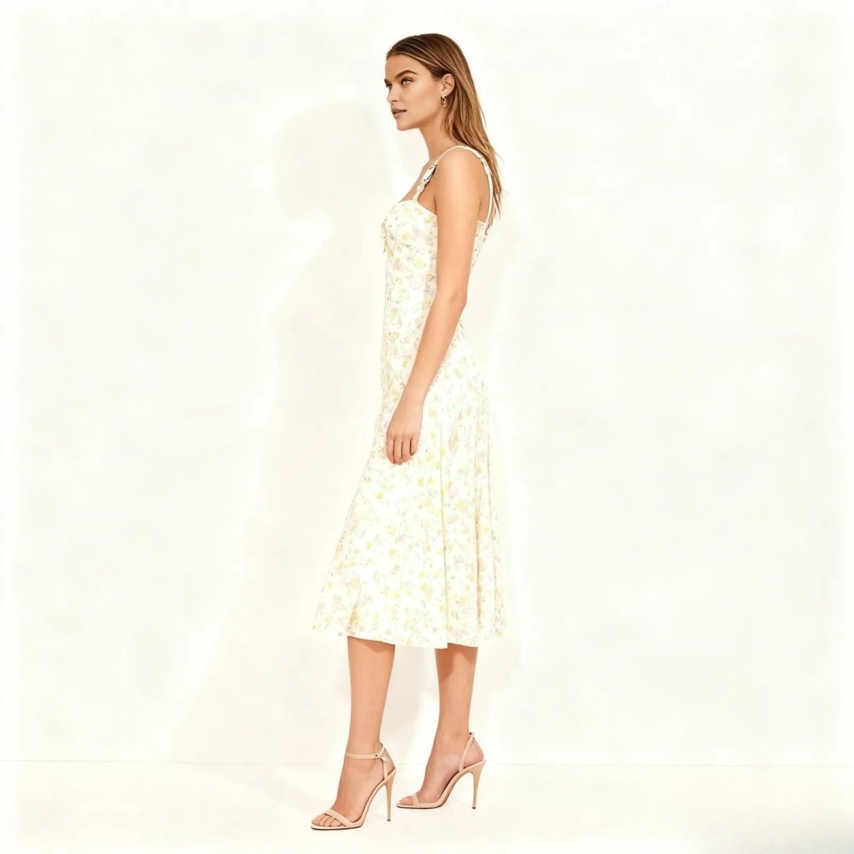 Woman wearing a ivory kouvr floral dress on a white background