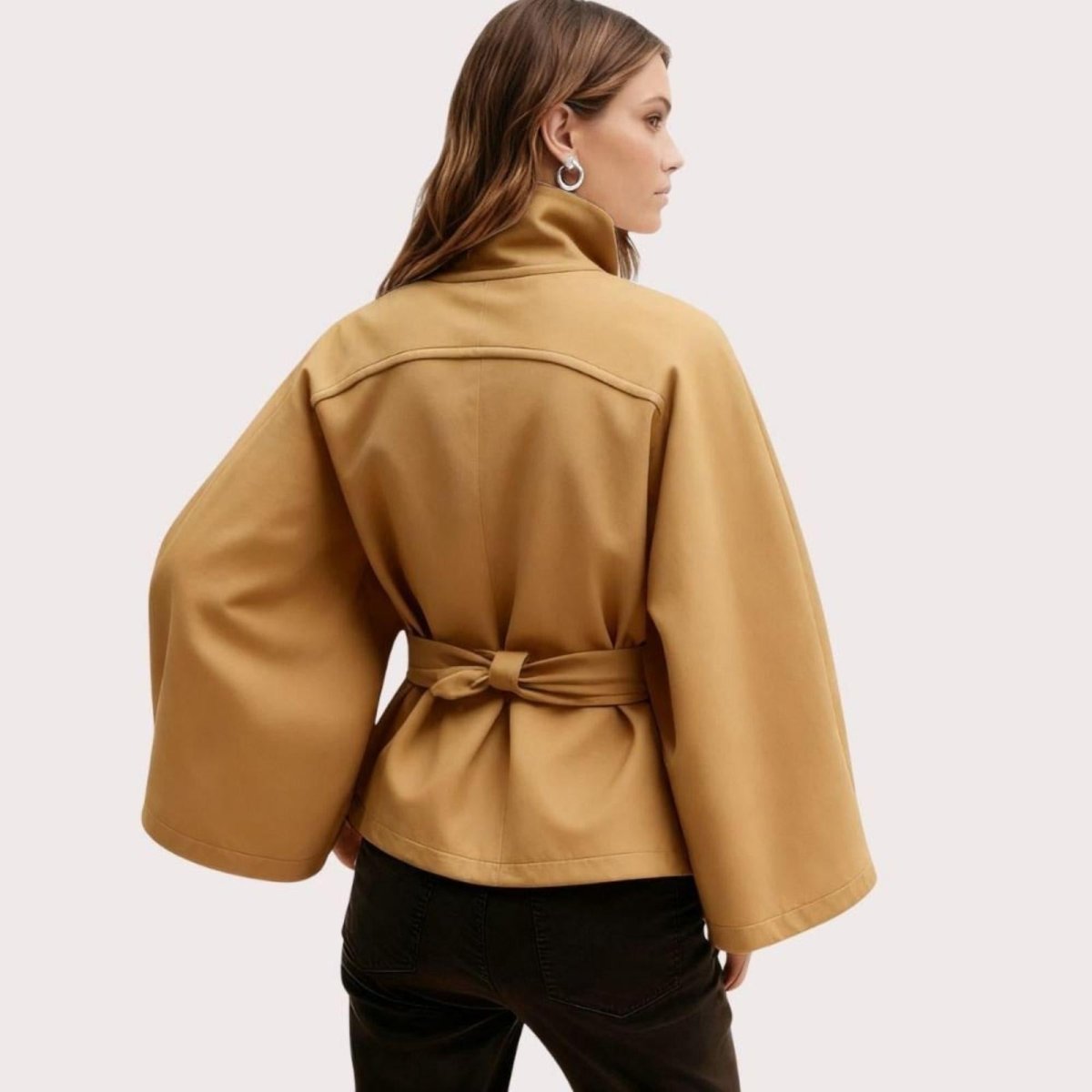 Model wearing Kouvr Fashion belted cape jacket with funnel neck and wide kimono sleeves