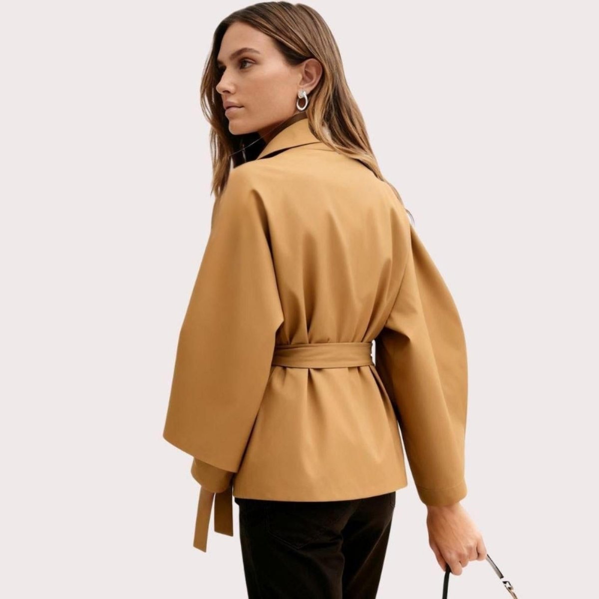 Model wearing Kouvr Fashion belted cape jacket with funnel neck and wide kimono sleeves