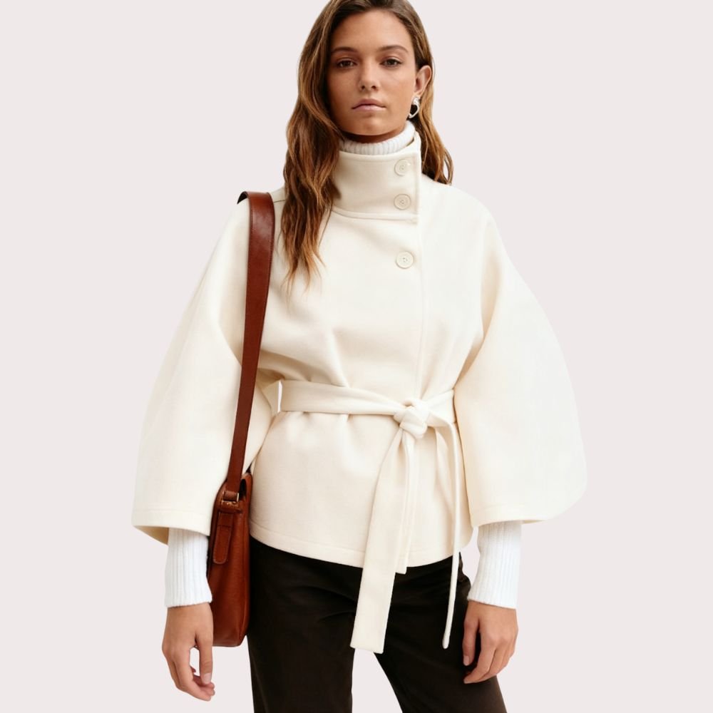 Model wearing Kouvr Fashion belted cape jacket with funnel neck and wide kimono sleeves