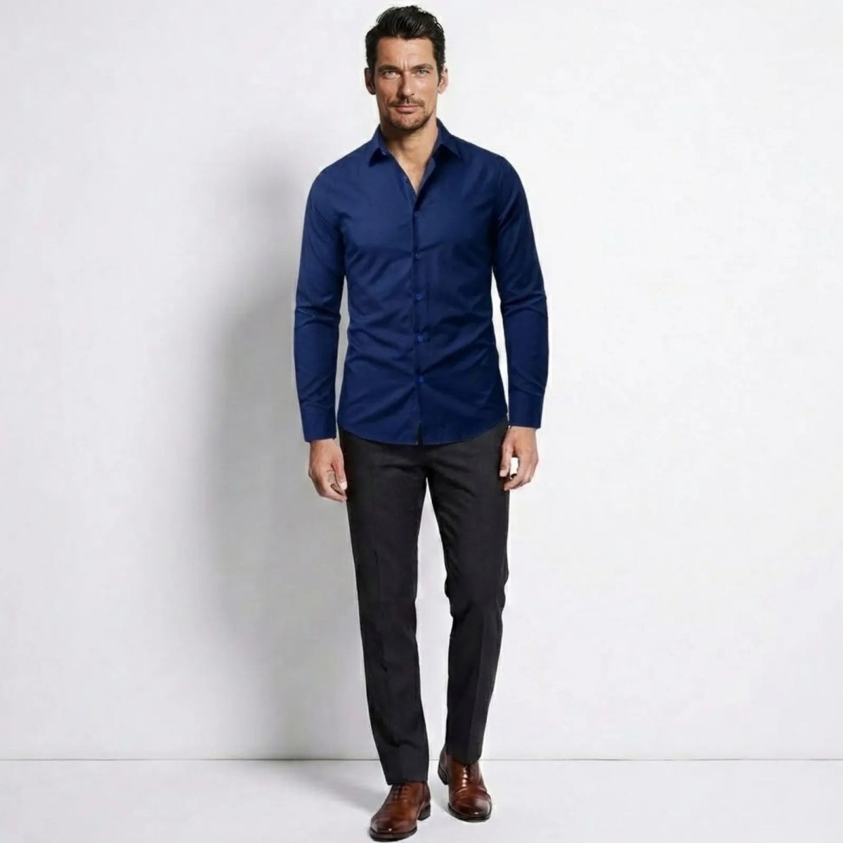 Model wearing the Kouvr Leland men's blue slim fit long sleeve dress shirt, styled with charcoal trousers.