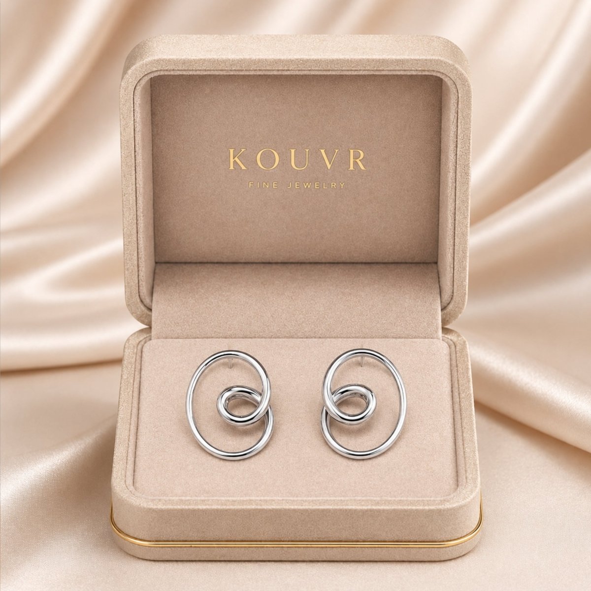 925 sterling silver intertwined loop knot stud earrings resting beautifully in a beige Kouvr luxury fine jewelry presentation box.