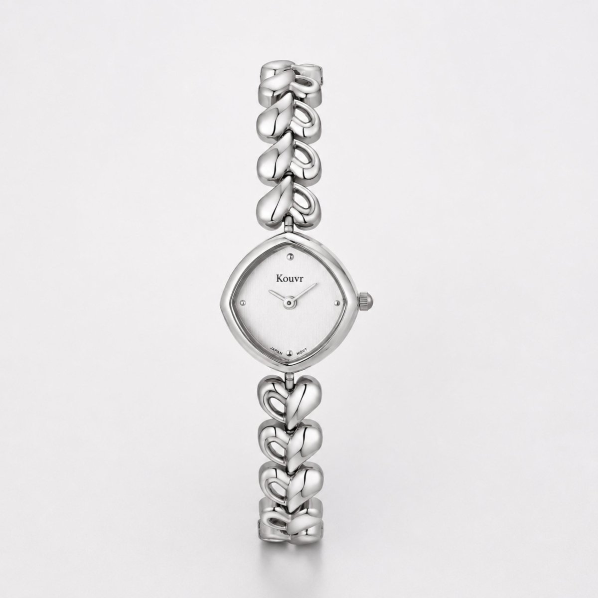 Clean studio photography of the Kouvr silver women's jewelry watch detailing the unique shield-shaped dial and high-polish heart links.