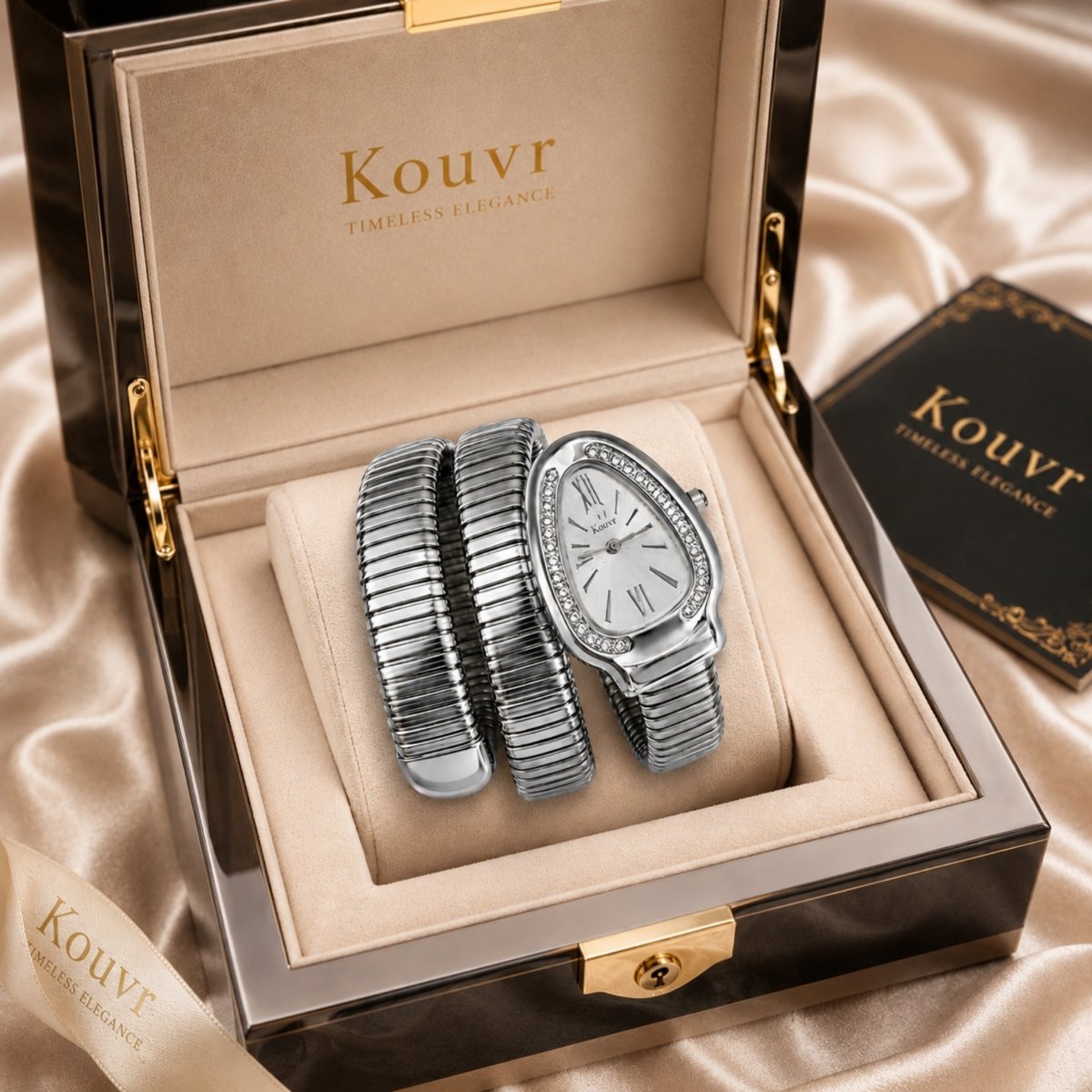 Kouvr silver snake wrap watch with crystal teardrop dial resting elegantly in a polished dark wood luxury gift box.