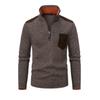 Flatlay of a men's brown quarter-zip sweater featuring a textured knit, suede shoulder and pocket details, and a vibrant orange inner collar lining.