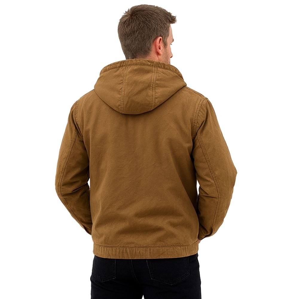 Man wearing the Kouvr tyrian sherpa-lined brown canvas hooded jacket, facing back with hands in pockets.