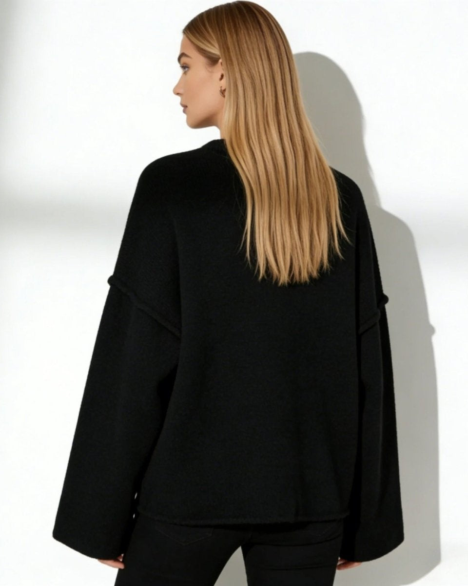 Back view of the Krystal oversized black sweater, showing the clean lines and dropped shoulder construction.