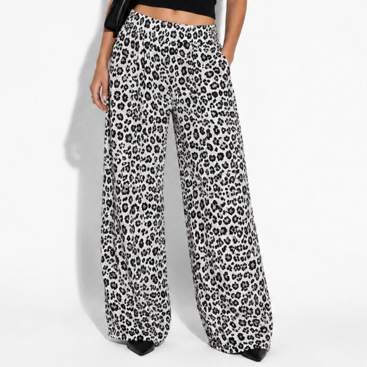Close up of women's luxury leopard print wide leg pants showing flowy high waisted drape and relaxed fit