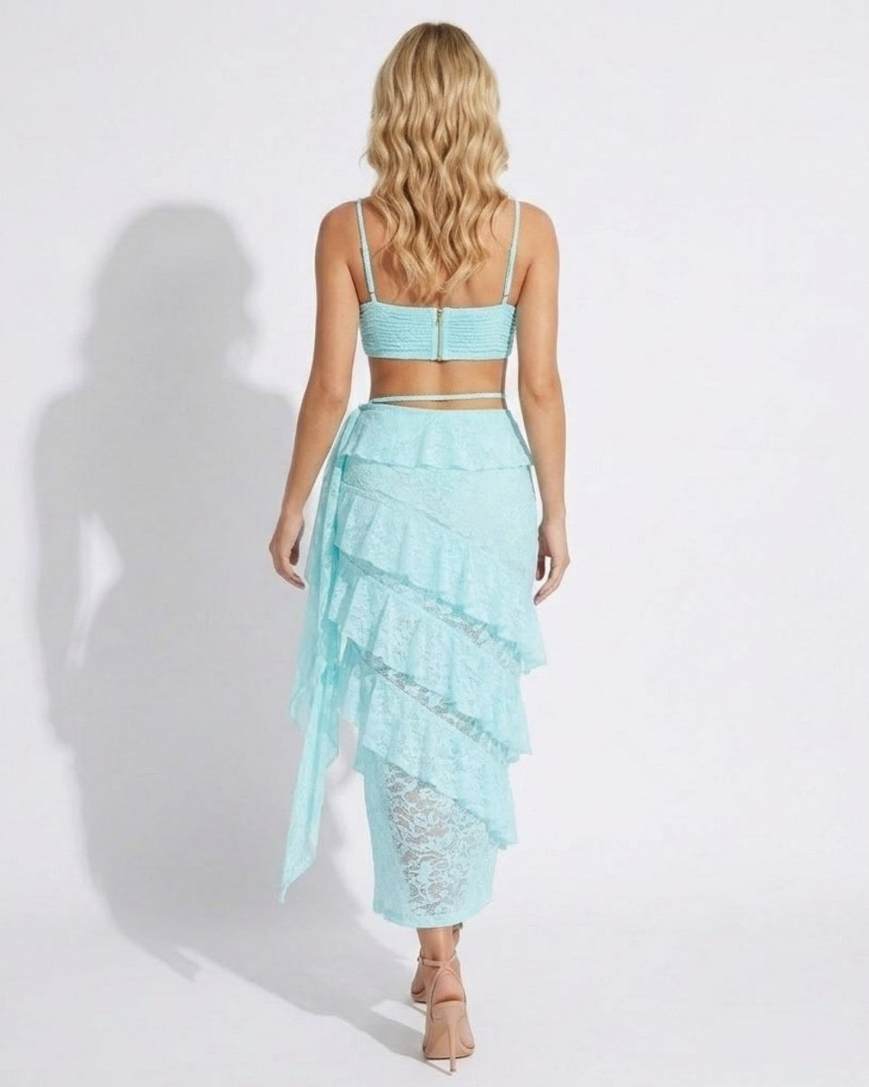 Back view of light blue lace two-piece outfit showing exposed zipper on bralette and asymmetrical sheer ruffle skirt details.