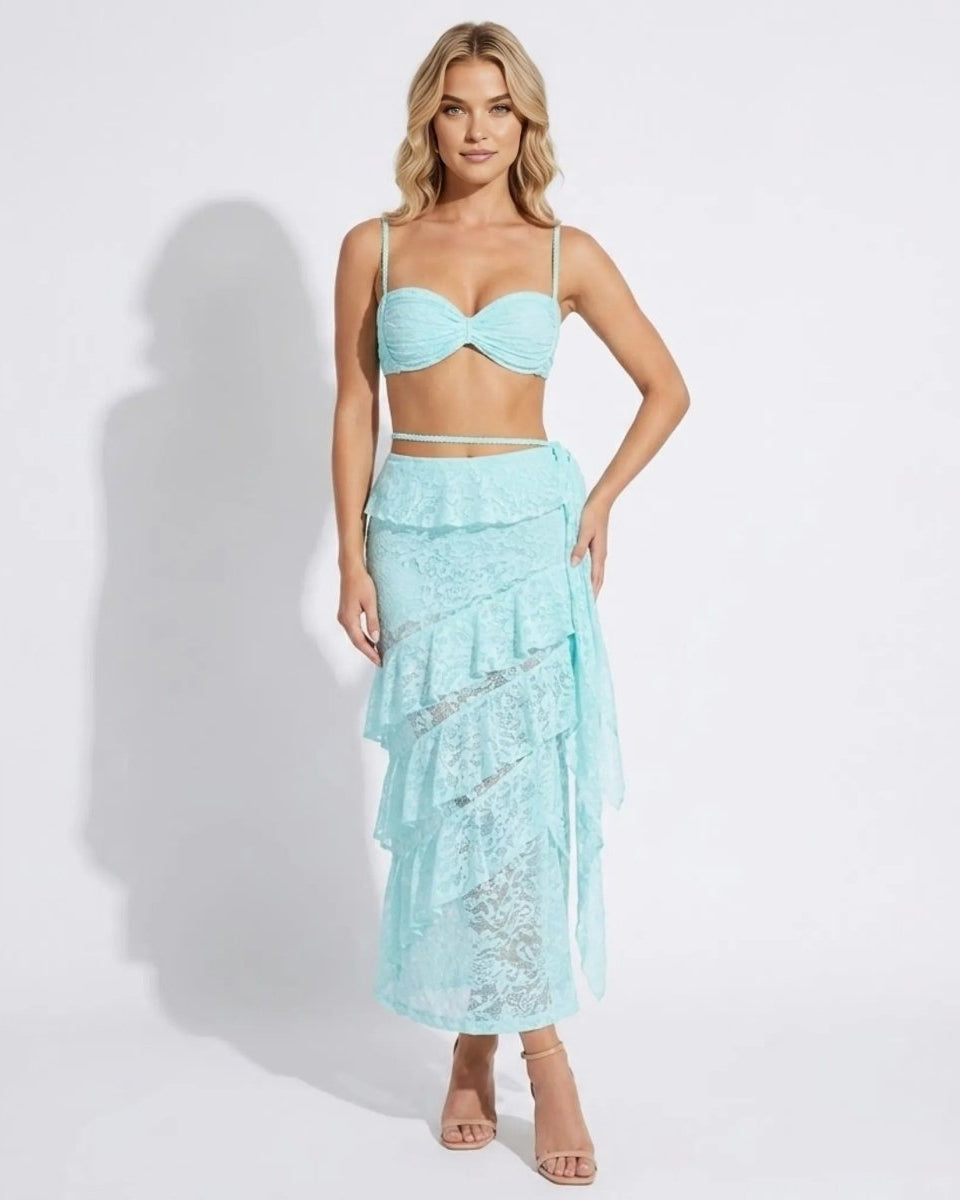 Woman wearing a luxury light blue lace tiered ruffle maxi skirt and matching ruched bralette two-piece set by Fenlo Form.