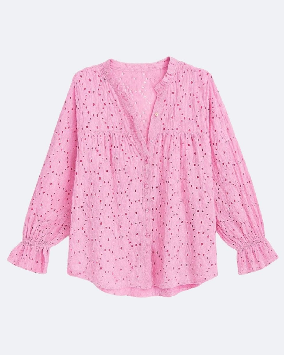 Flatlay product shot of the front of the pink eyelet blouse, showing the ruffled collar, button placket, and ruffled cuffs.
