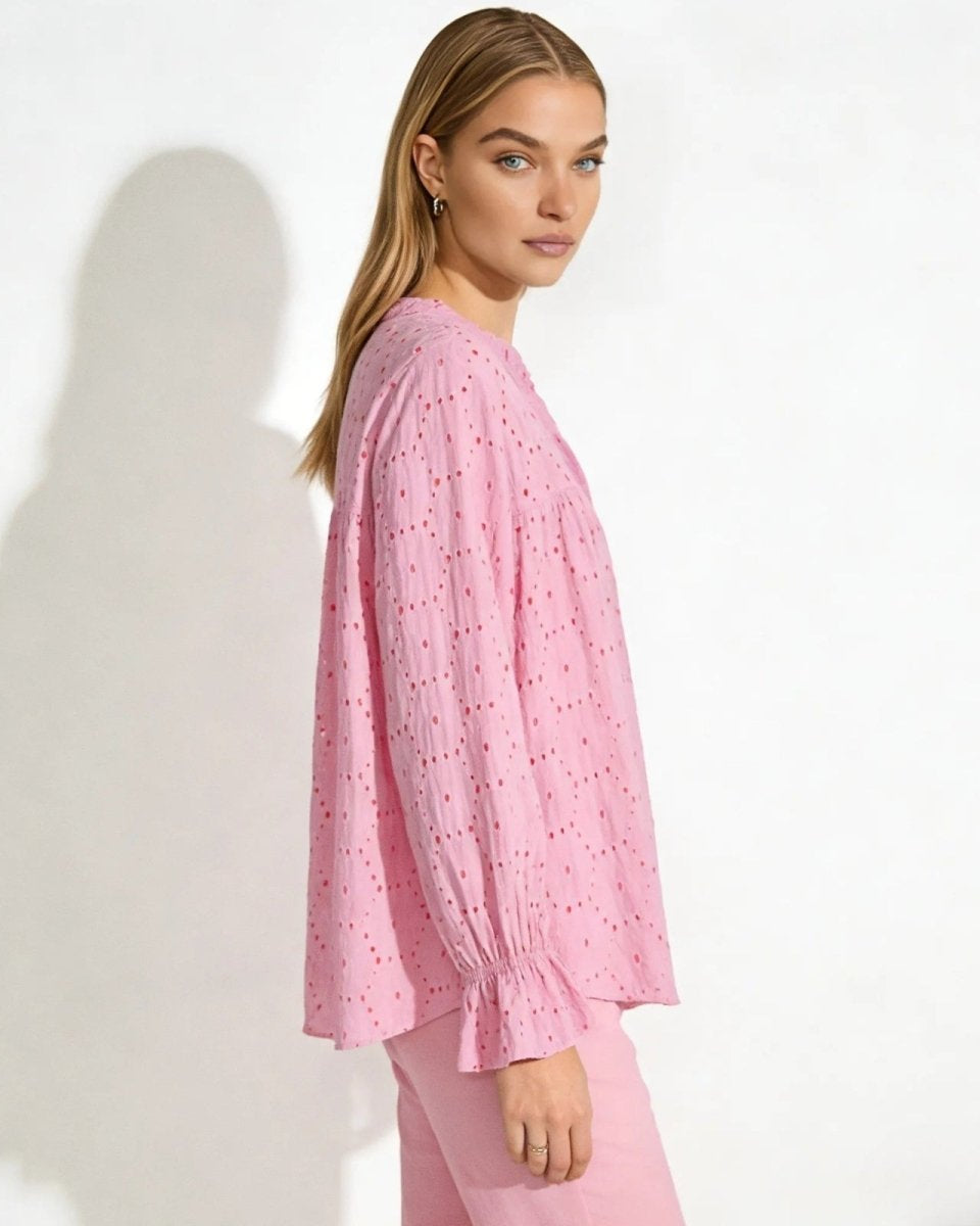Side profile of a woman wearing the pink boho eyelet blouse, highlighting the voluminous bishop sleeves and relaxed fit.