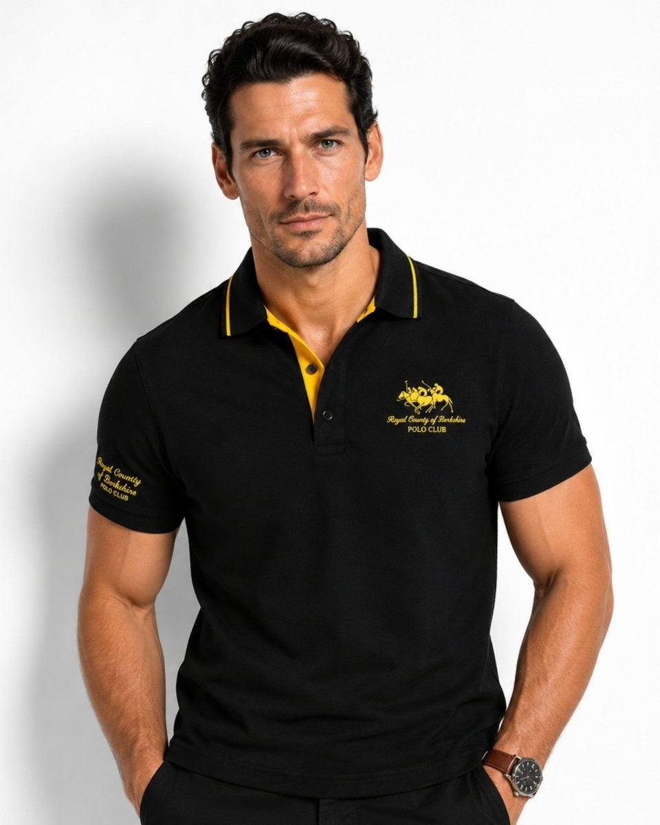 Man wearing a black polo shirt with yellow accents and a logo on a white background