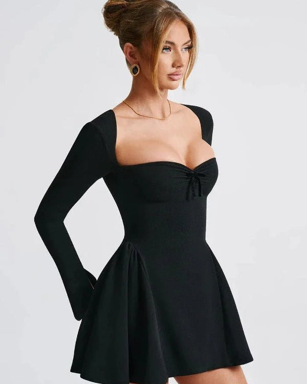 Woman wearing a black dress with long sleeves on a white background