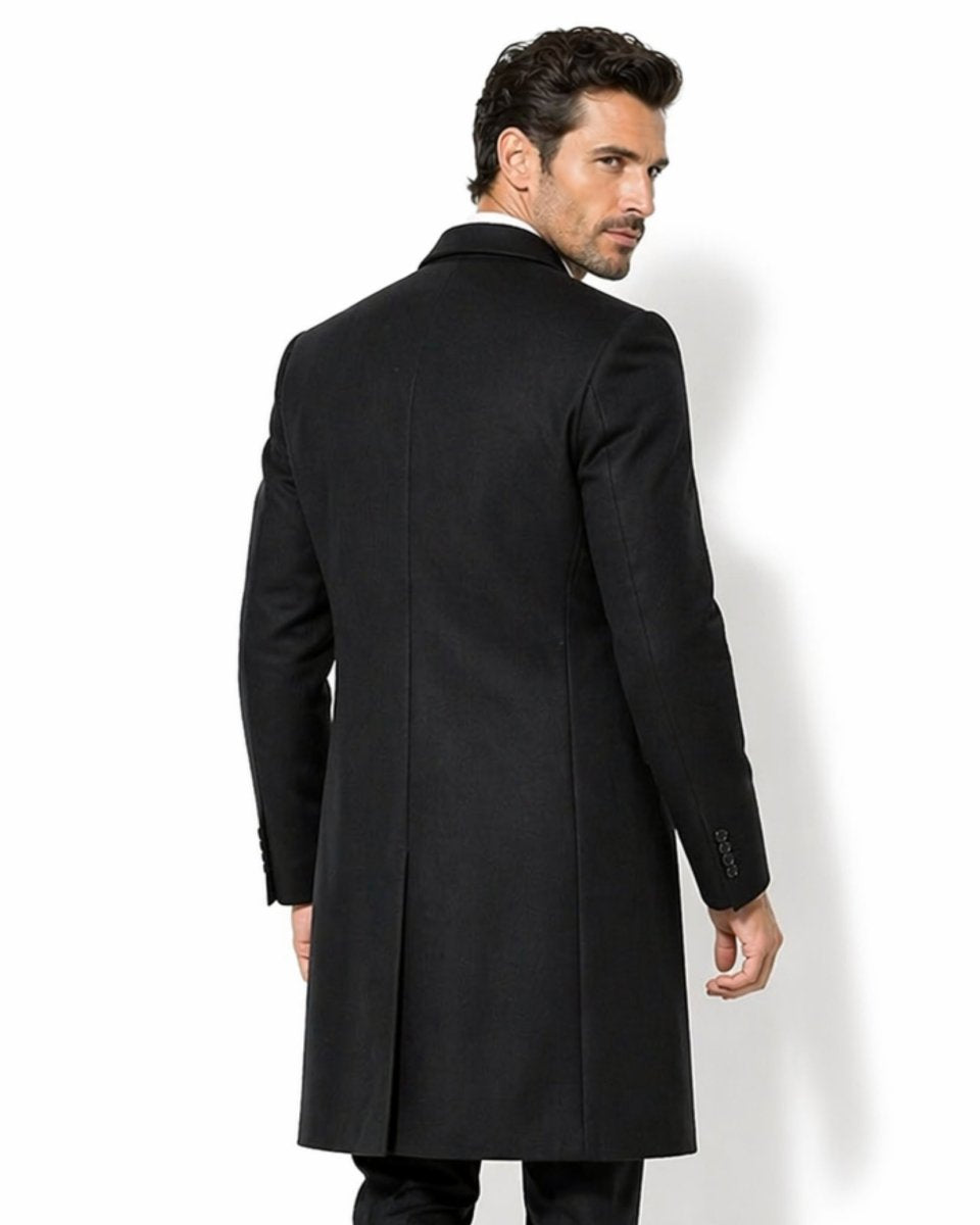 Back view of men's black formal overcoat showing the single center back vent and precise tailored fit across the shoulders.