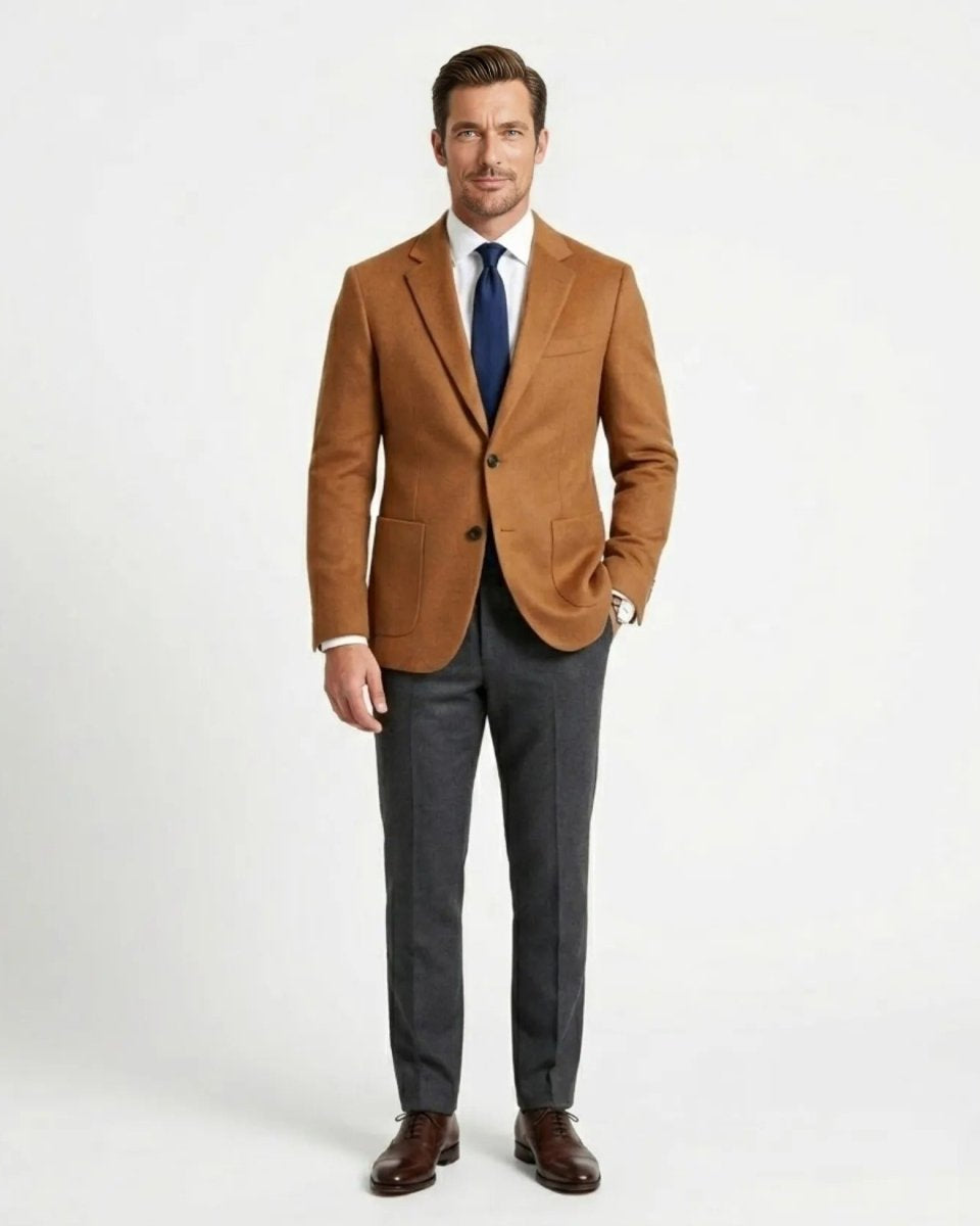 Male model styling the Fenlo Form camel wool sport coat with grey trousers and navy tie