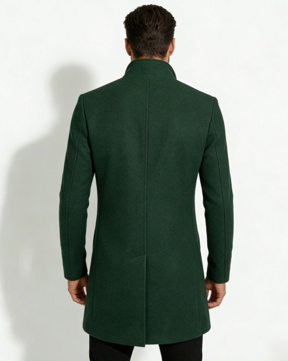 Back view of a man wearing a dark green winter overcoat, highlighting the center vent and structured shoulders.