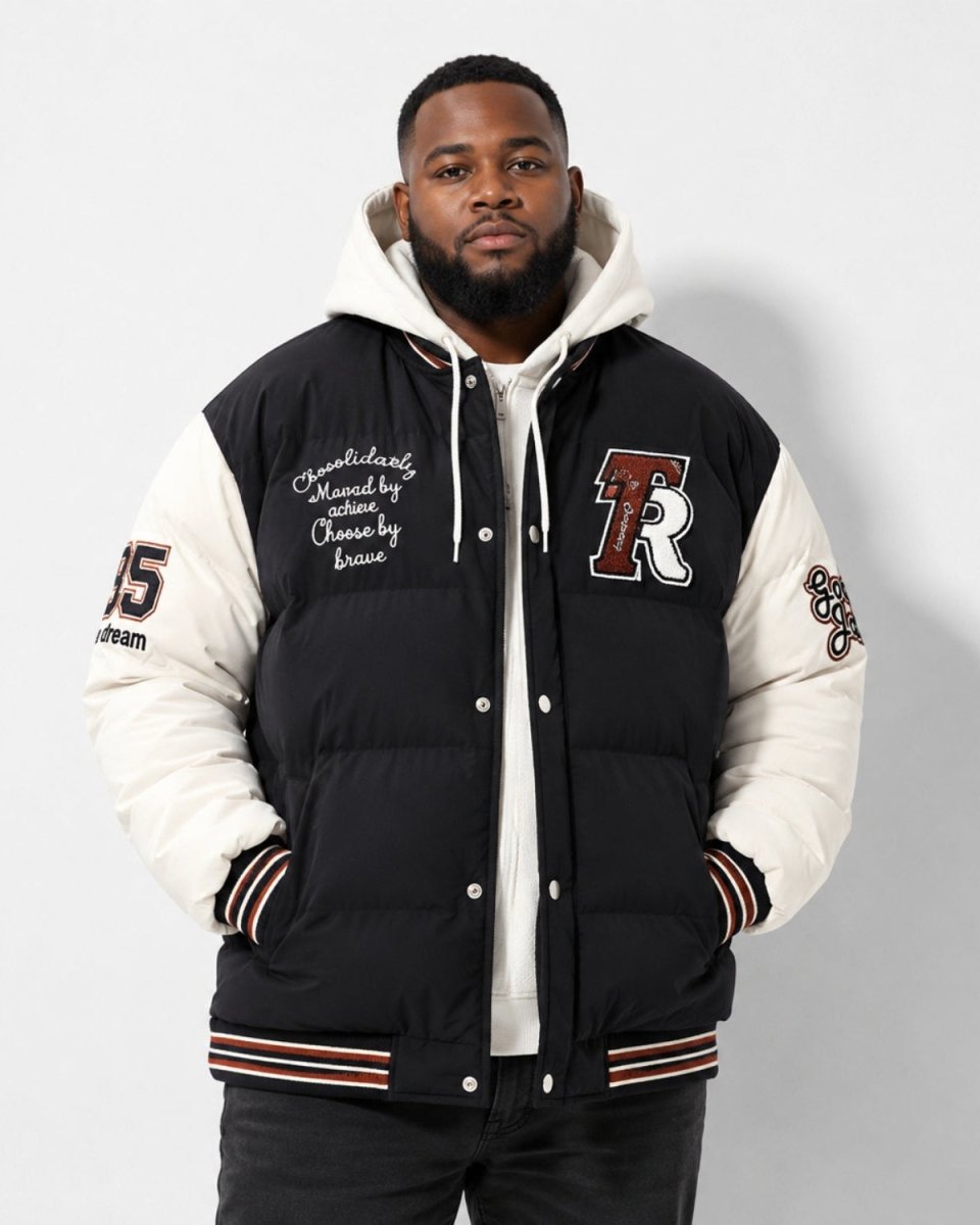A man wearing a black and off-white varsity-style puffer jacket with a white hood, featuring embroidered details and a large 'R' logo on the chest, posed against a light gray studio background.